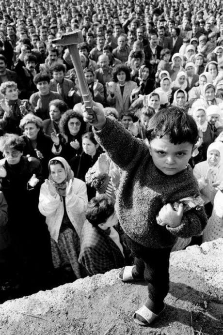 a crowd of people watching a young boy on a skateboard