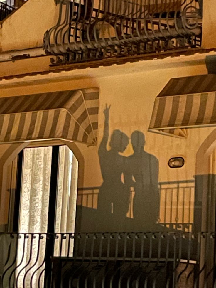 the shadow of two people on a building