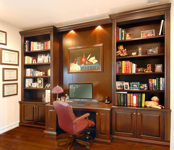 a home office with bookshelves, desk and chair in front of the wall