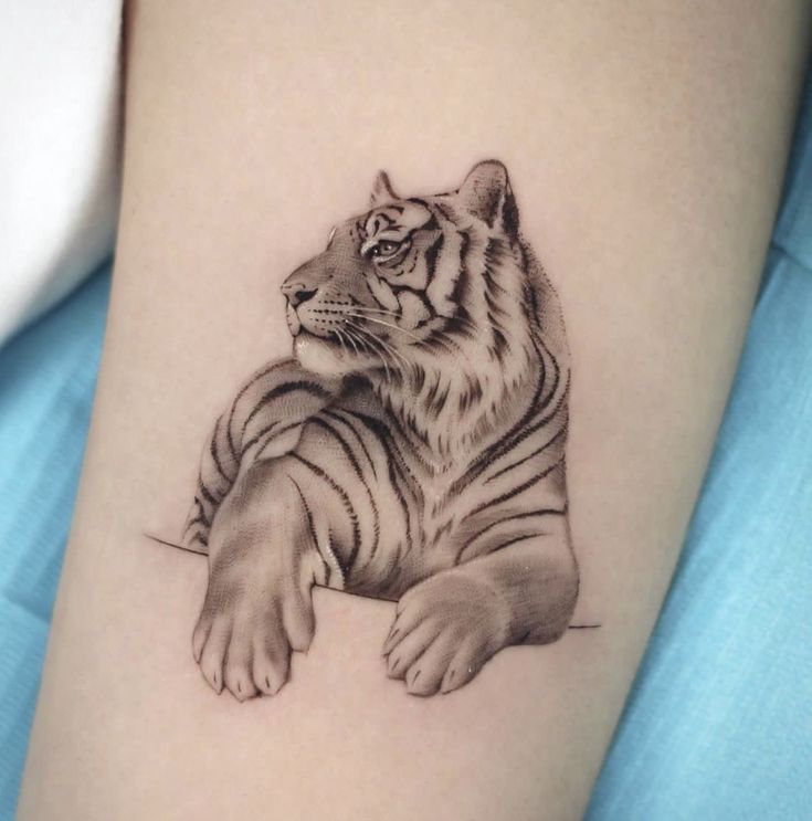 a black and white tiger tattoo on the arm