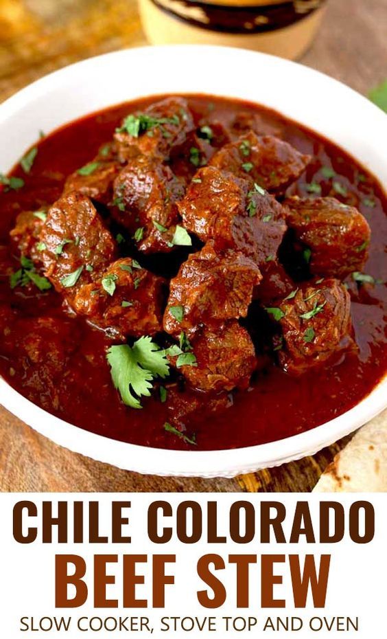 a white bowl filled with beef stew and garnished with cilantro