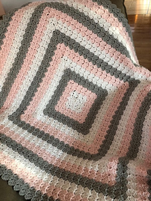 a crocheted blanket sitting on top of a couch