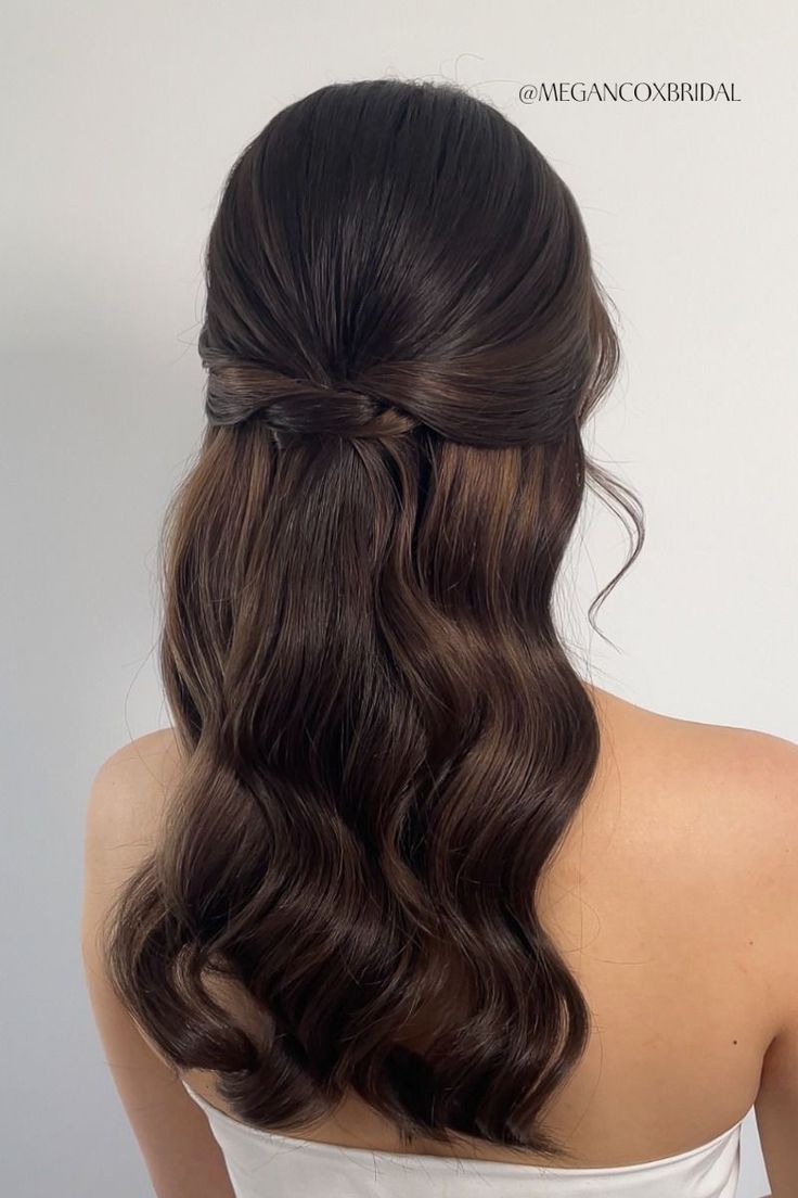 the back of a woman's head with long dark brown hair, wearing a white dress