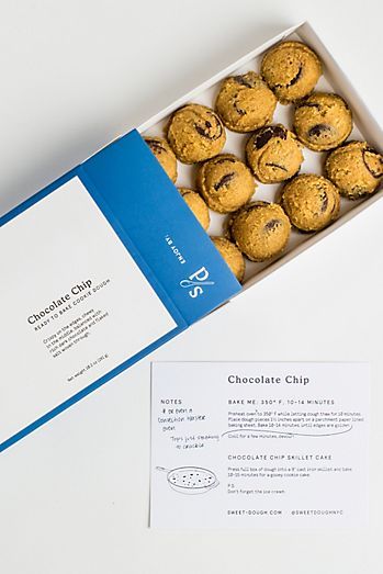 a box filled with cookies sitting on top of a white table next to an envelope