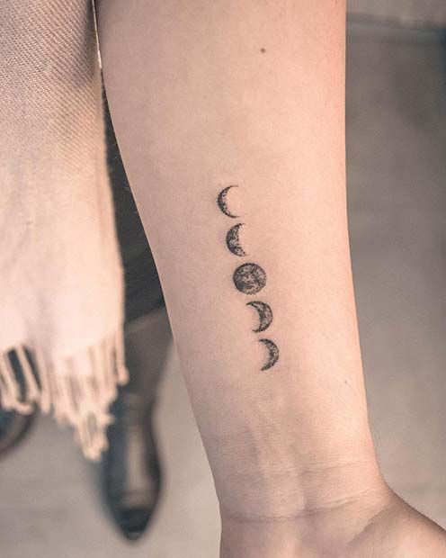 a woman's foot with three phases of the moon tattoo on it