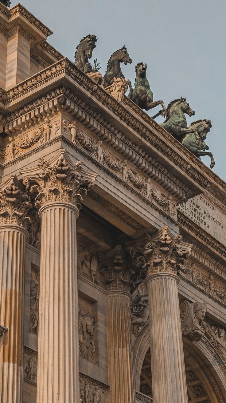 an old building with columns and statues on top