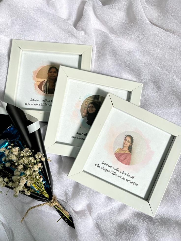 three framed pictures on a bed with flowers in the foreground and a bouquet of baby's breath