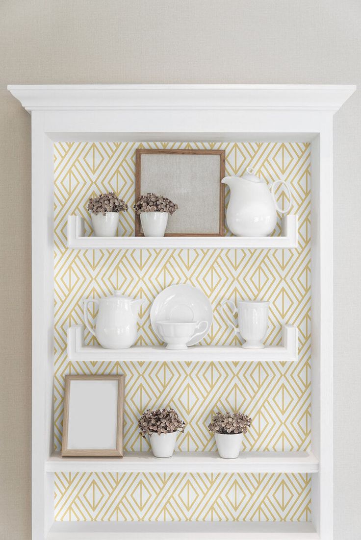 a white shelf filled with dishes and cups