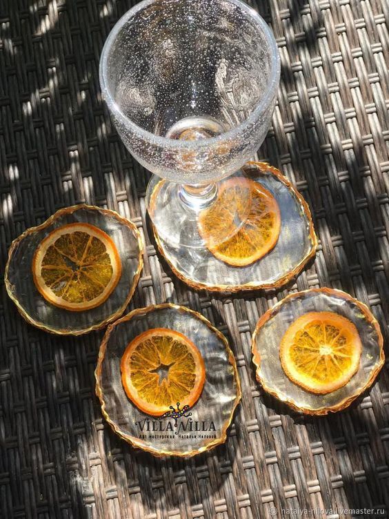 four slices of orange sitting on top of small plates next to a glass bowl filled with water