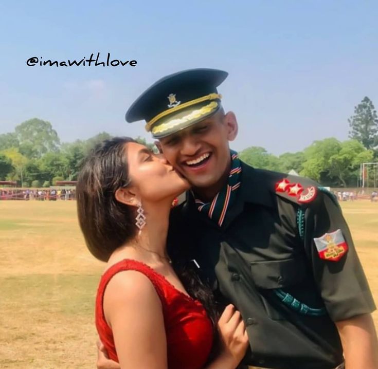 a man in uniform kissing a woman on the cheek