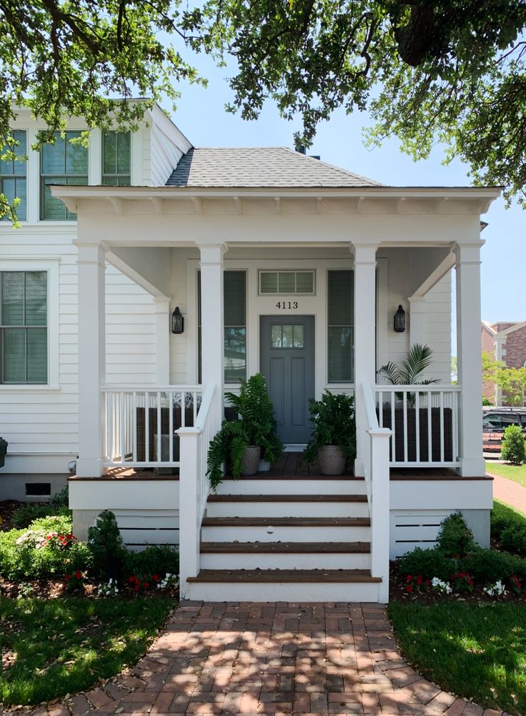 a white house with steps leading up to the front door