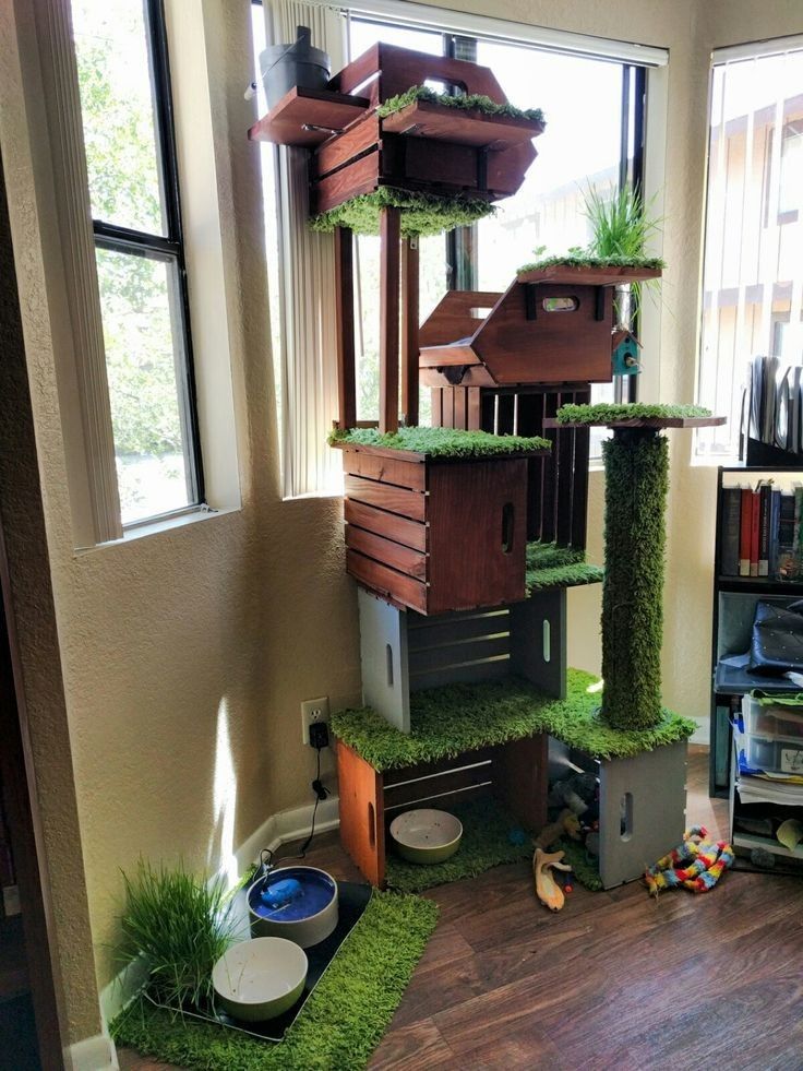 the cat house is made out of wood and artificial grass with plants growing on top