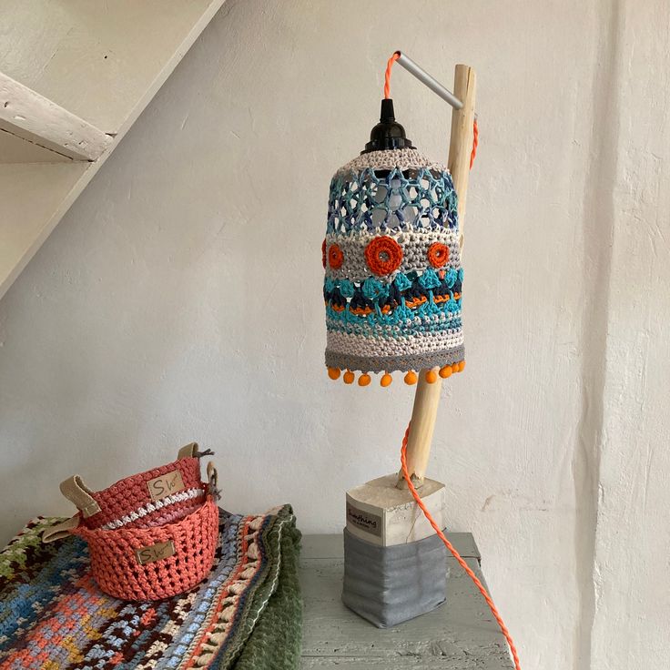 a lamp that is on top of a table next to a basket and rugs