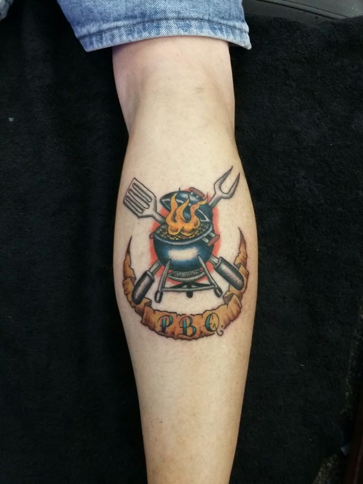 a person with a tattoo on their leg holding a knife and fork in the other hand