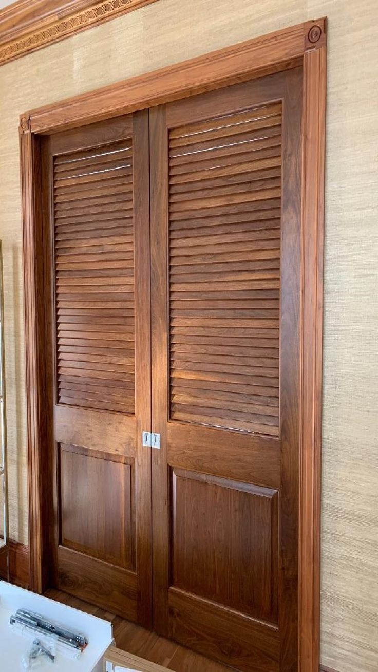 a bathroom with two wooden doors and a sink