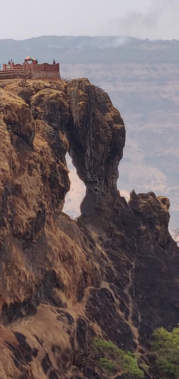 people are standing on the edge of a cliff