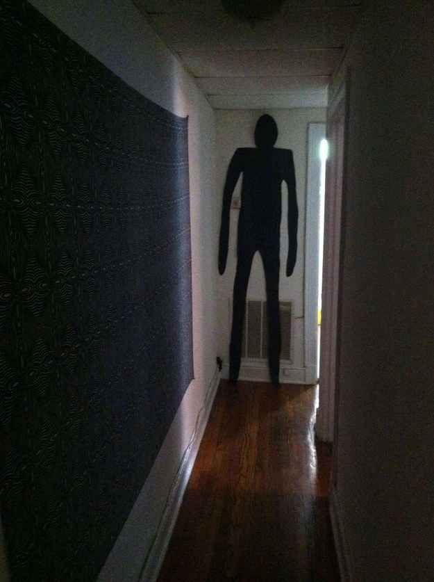 the man is standing in the hallway next to the door