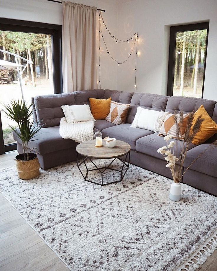 a living room filled with lots of furniture and decor on top of a white rug