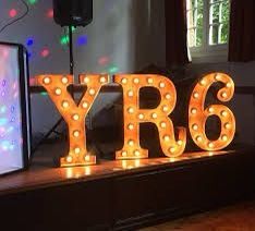 a large light up sign sitting on top of a wooden table