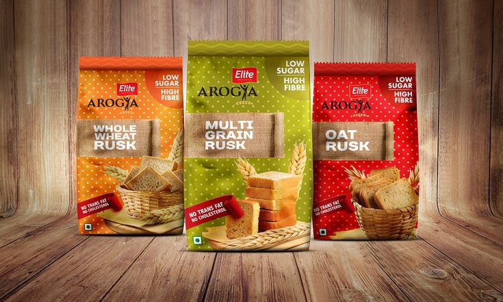 three bags of bread with labels on them sitting next to each other in front of a wooden background