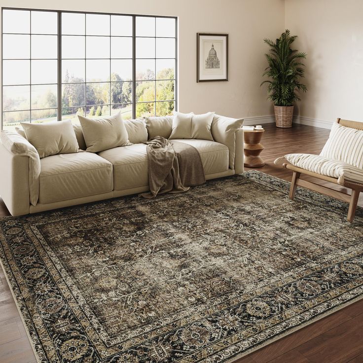 a living room with a large rug on the floor and windows in the back ground