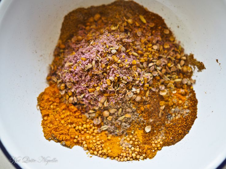 a white bowl filled with spices on top of a table