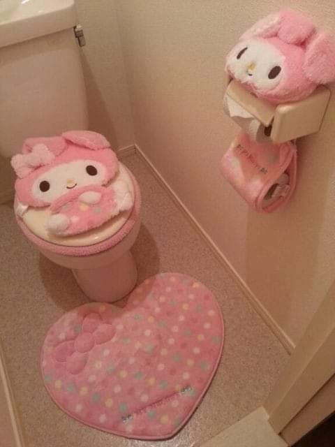 a bathroom with hello kitty rugs on the floor next to a toilet and sink