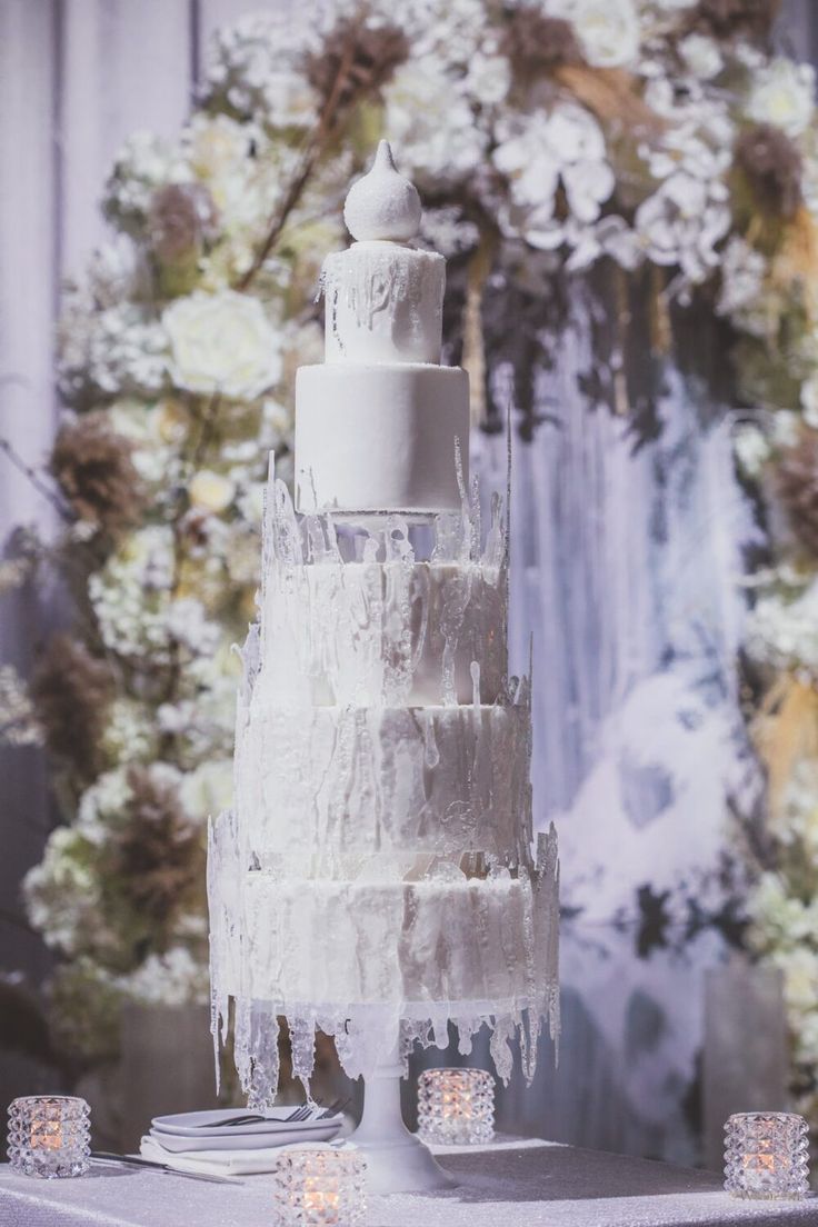 a white wedding cake with icing and candles