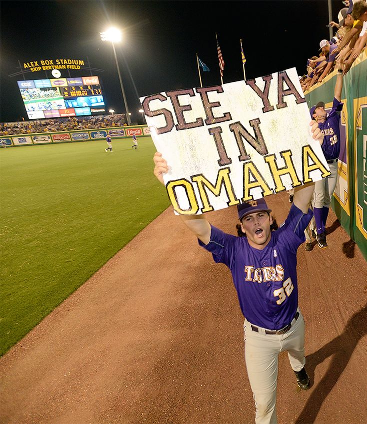 a baseball player holding up a sign that says see ya in omaha on the field