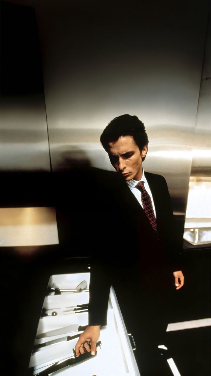 a man in a suit and tie leaning on a counter with his hand on the tray