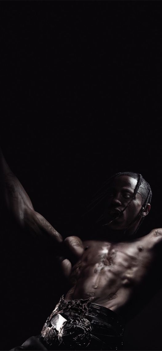 a man laying on top of a bed in the dark with his arms stretched out