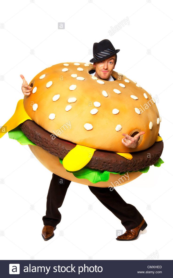 a man in a hamburger costume is walking with his hand up to the camera and pointing