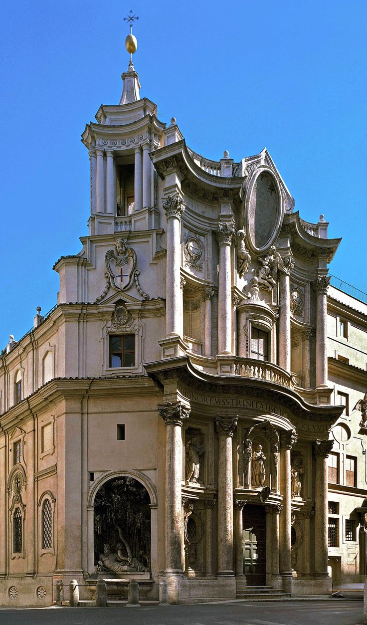 an old building with a clock on it's side in the middle of town