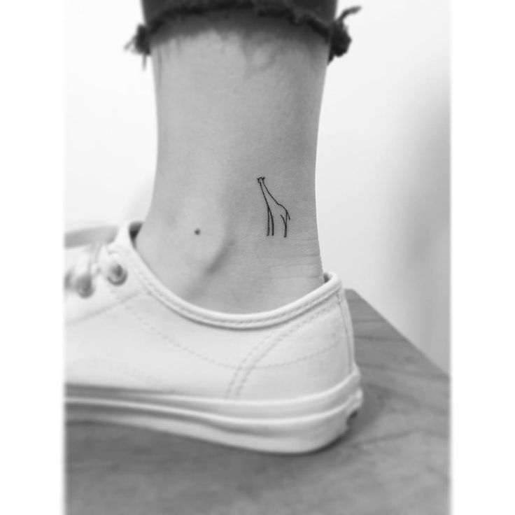 a small giraffe tattoo on the side of a woman's neck and foot