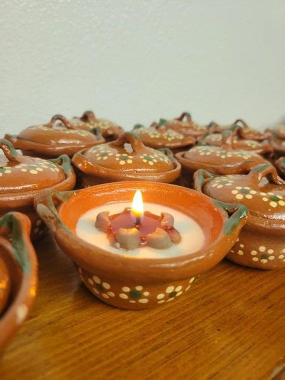 there is a small candle that is in the middle of some brown bowls on a table