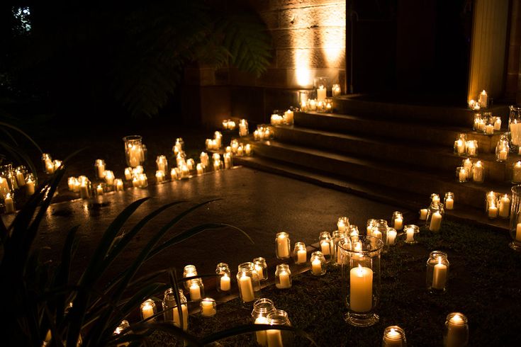 many lit candles are placed on the ground