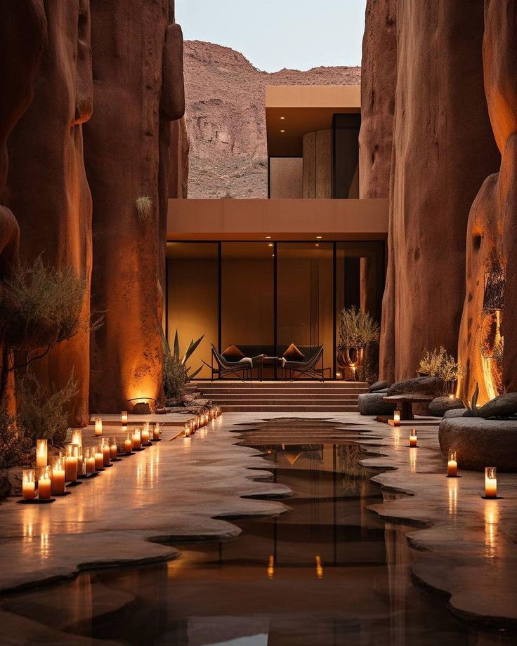 candles are lit in the middle of a pool surrounded by rocks