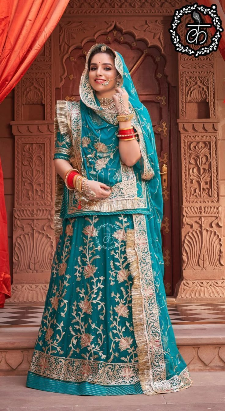 a woman in a blue and gold lehenga