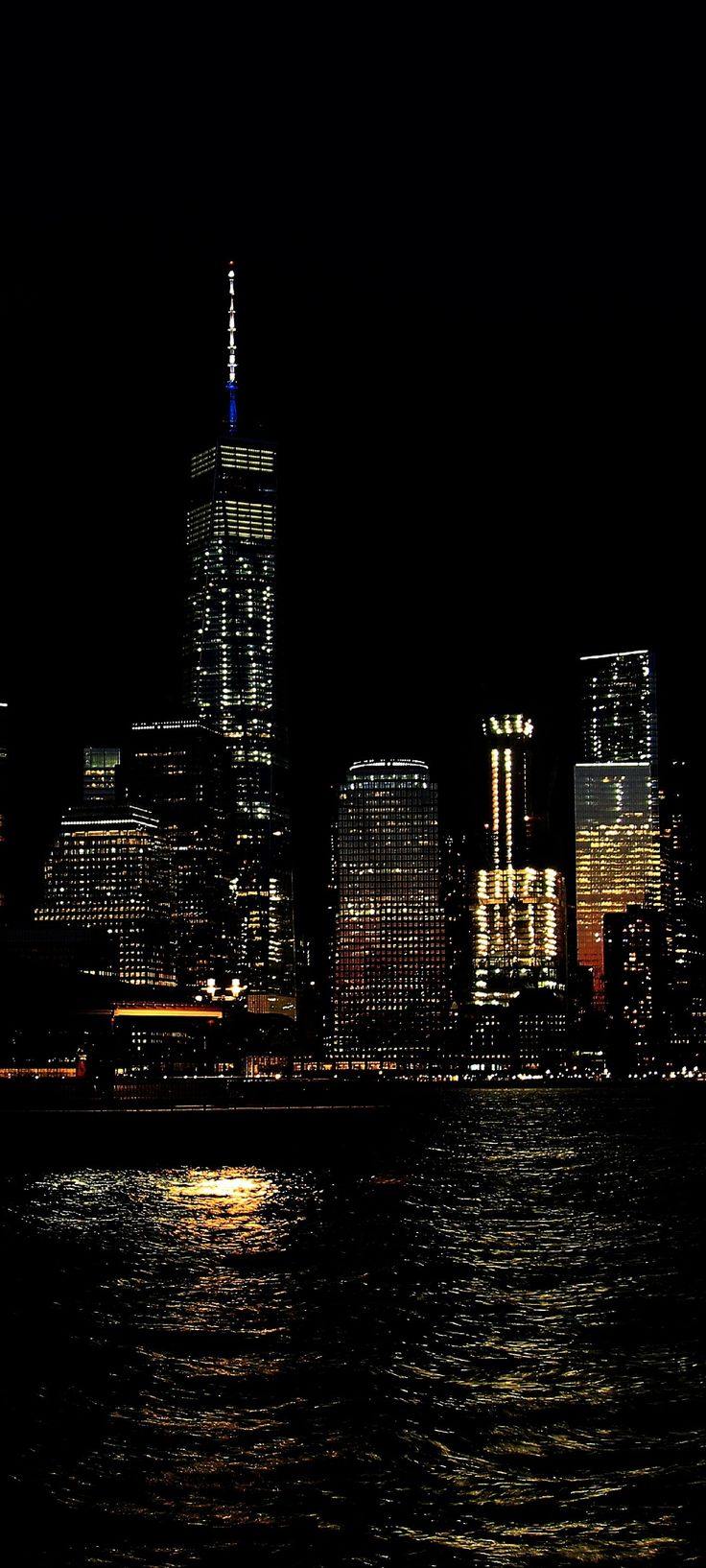 the city is lit up at night and it looks like they are floating in the water