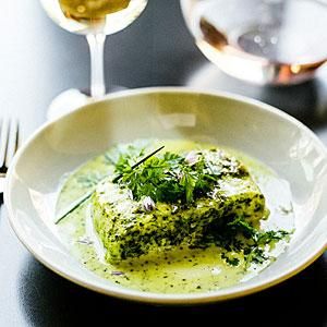 a white plate topped with food next to a glass of wine