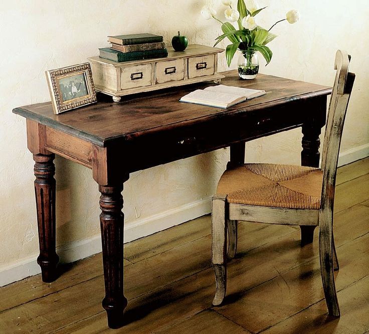 a wooden desk with a chair next to it and a potted plant on top