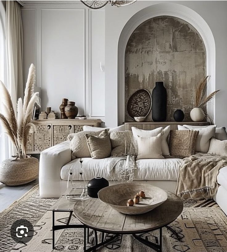 a living room filled with white furniture and lots of pillows on top of it's couch