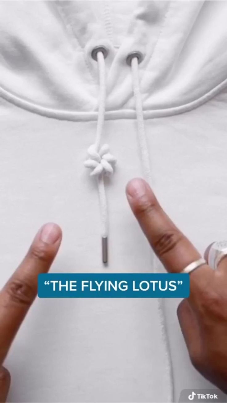 two hands holding onto the side of a white shirt that says, the flying lotus