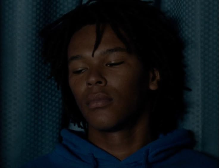 a man with his eyes closed wearing a blue hoodie