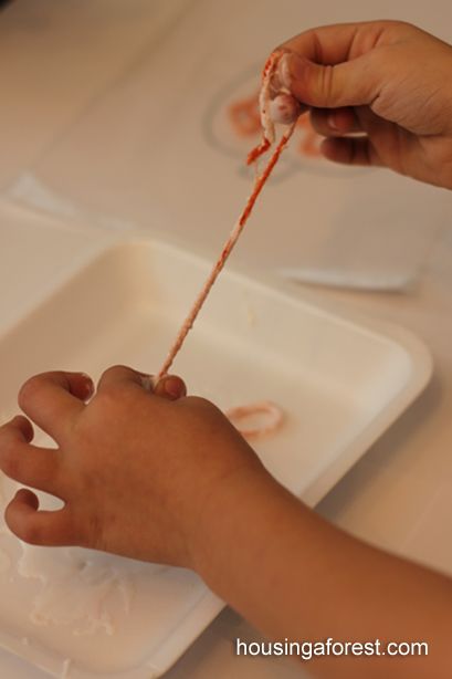 a child is holding a toothbrush in their hand while sitting at a white table