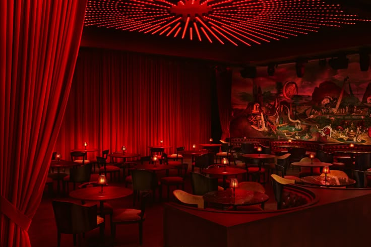 a dimly lit restaurant with red curtains and tables