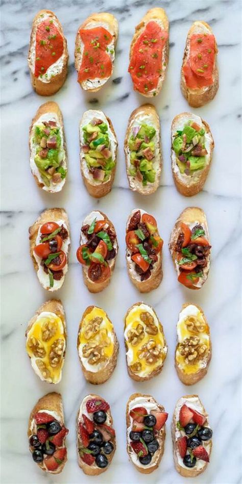 an assortment of sandwiches with different toppings on them sitting on a marble counter top