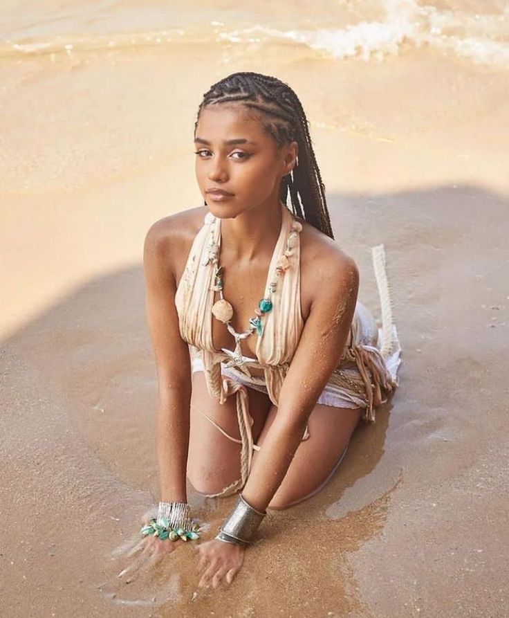 a woman sitting in the sand on the beach