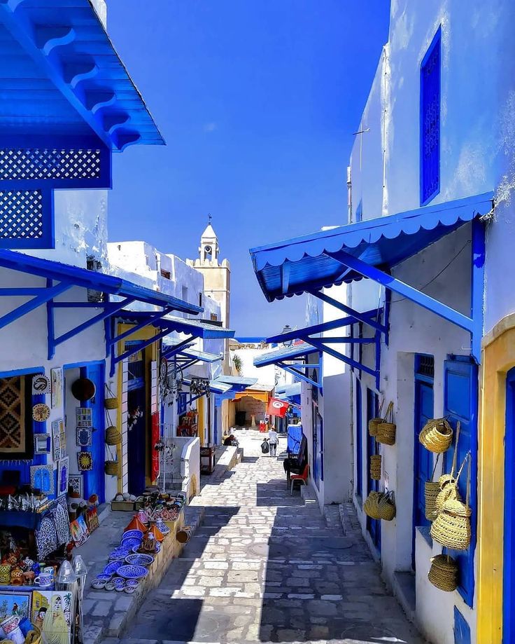 an alley way with blue and white buildings