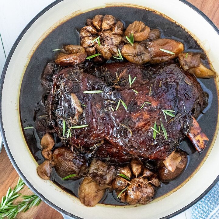 a pan filled with meat and mushrooms on top of a wooden table